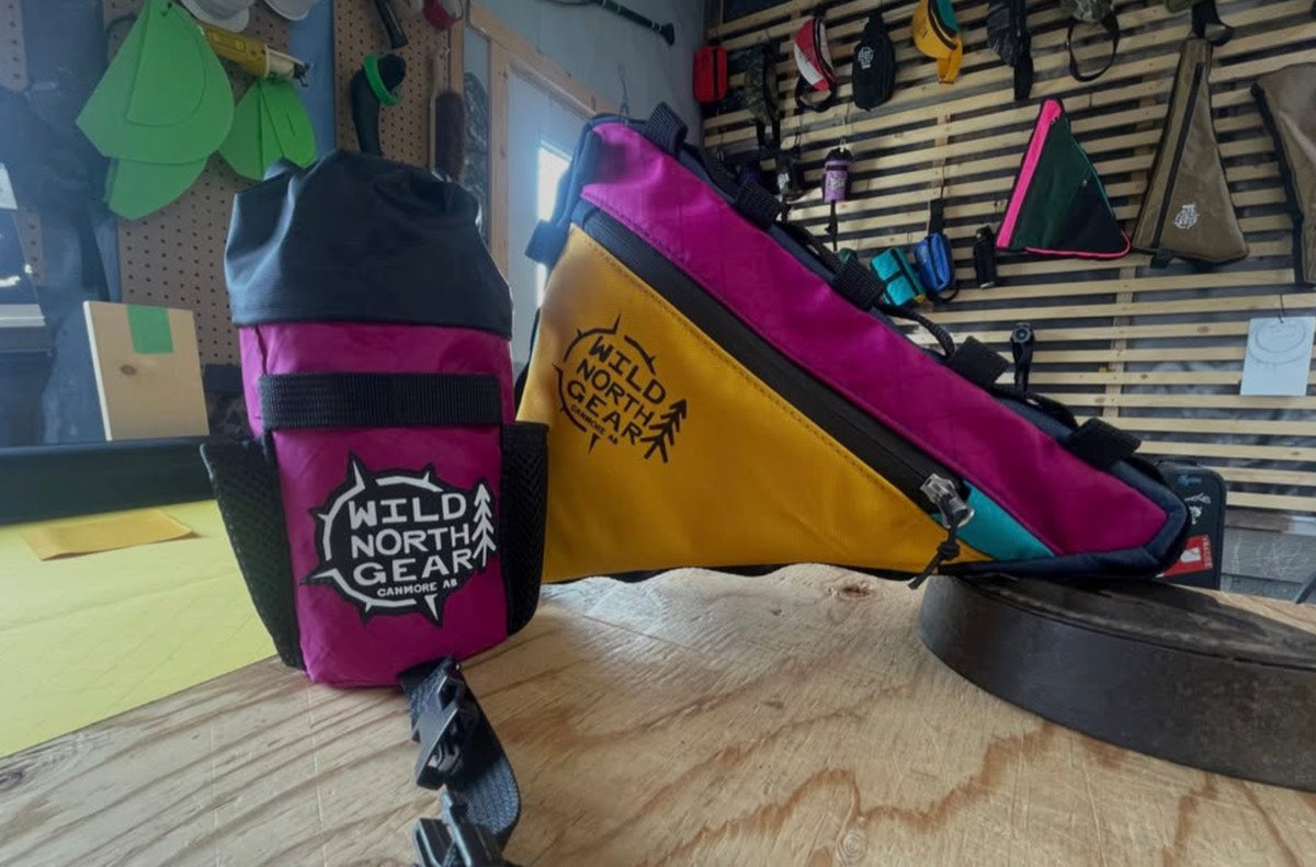 Fuchsia, gold and teal frame bag with a matching stem bag on the workbench