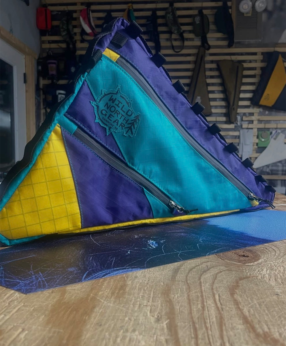 Purple, teal and yellow ripstop frame bag on the workbench