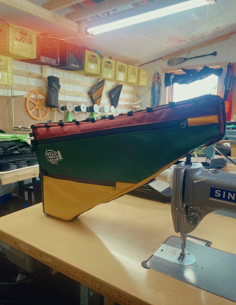 Burgundy, forest and mustard full frame bag propped on the Singer sewing machine