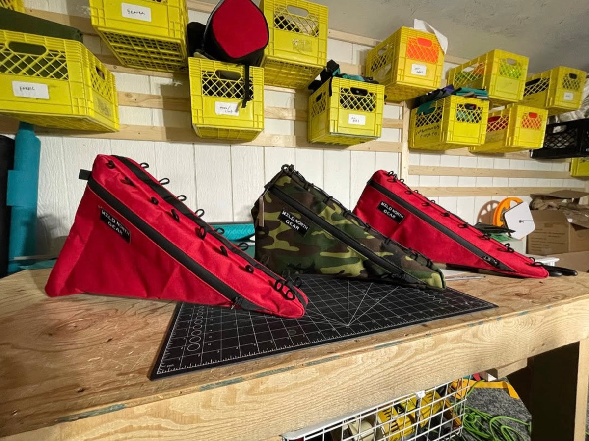 Two red frame bags and a camo frame bag on the cutting mat